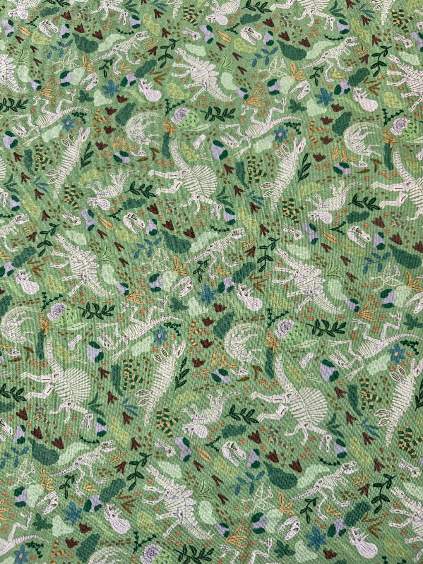 Prehistoric Dinosaurs - Skeletons and Foliage on a Green Background
